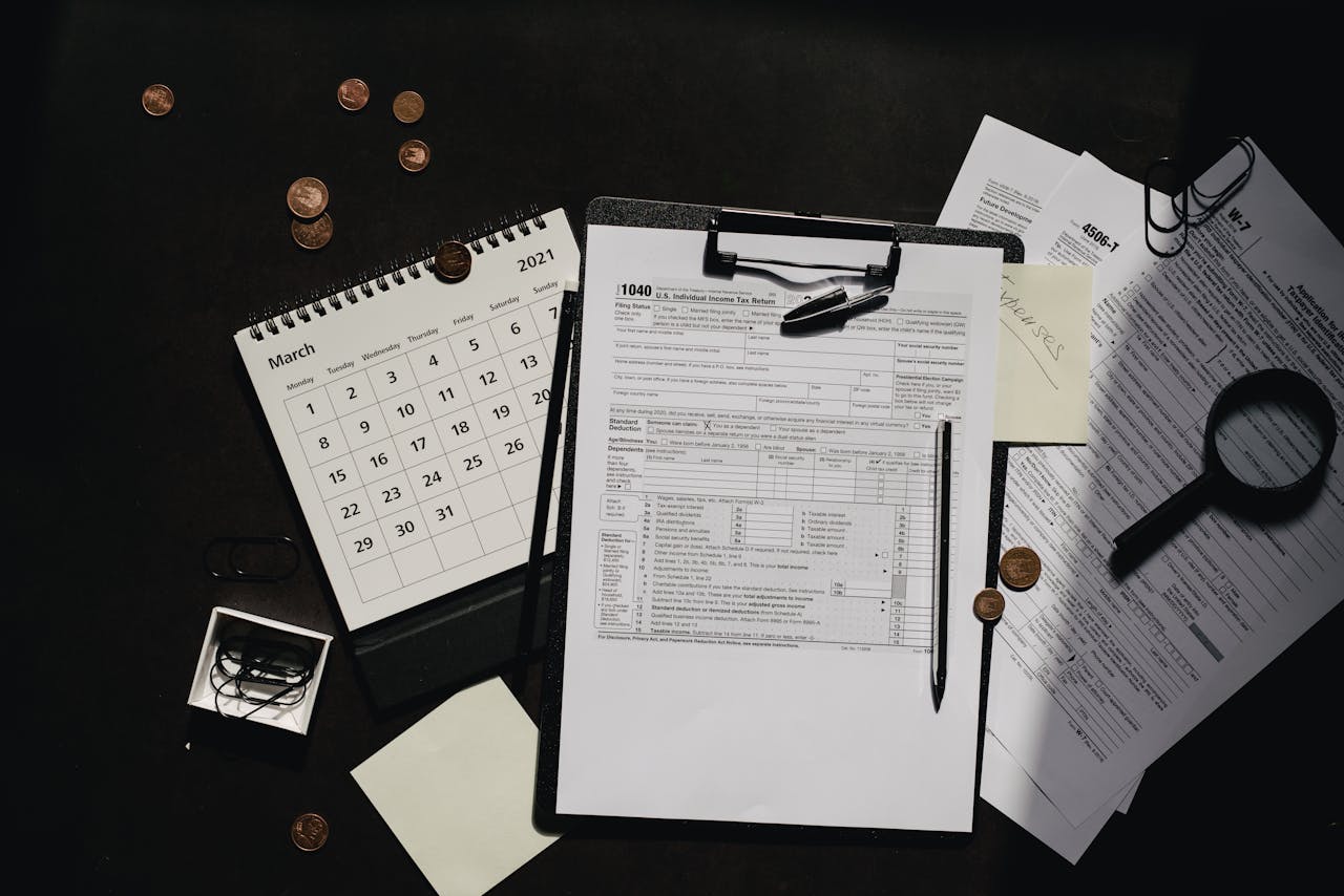 A neatly organized workspace featuring tax forms, calendar, magnifying glass, and office supplies for efficient tax preparation.